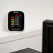 Air quality meter on a white wall with a blurred background