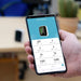 Hand holding a smartphone displaying an app with environmental monitoring data.