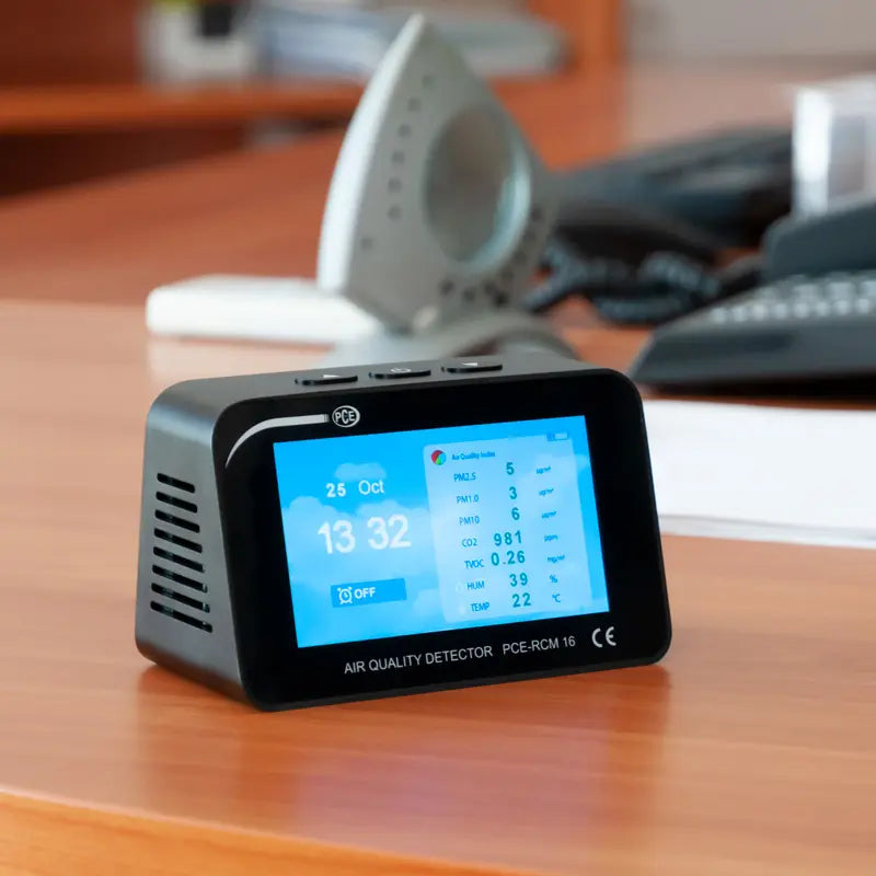 Air quality detector on a desk with office equipment in the background