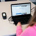 Person using a laptop with multiple devices connected on a desk