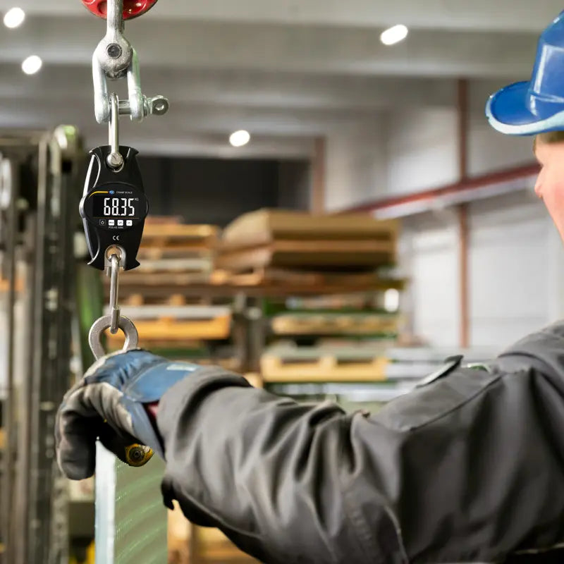 Person using a digital weight indicator in a warehouse setting