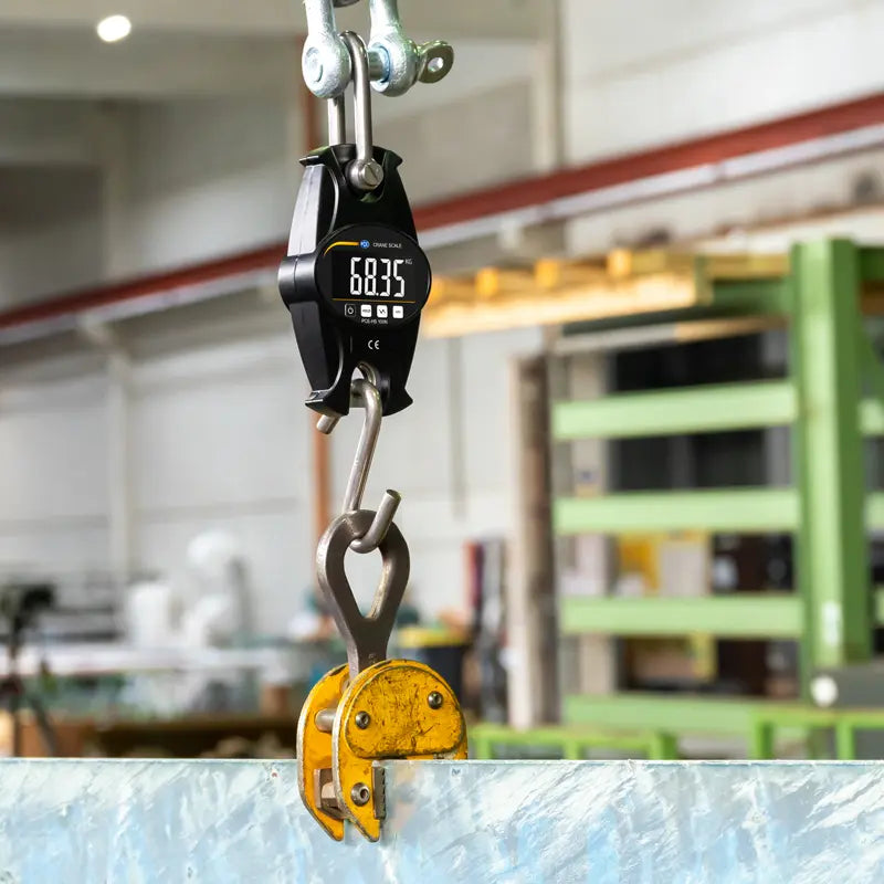 Digital crane scale with a hook in an industrial setting