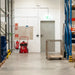 Warehouse interior with fire extinguishers, pallets, and a door.