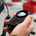 Hand holding a light meter with a white bulb inside, blurred background