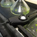 light meter with a white ball on a reflective surface with green liquid.