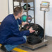 Person working with coiled cable on a weighing scale in a controlled environment