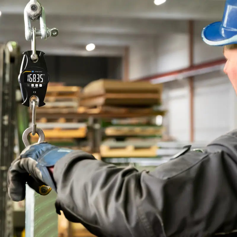 Person using a digital weight indicator in a warehouse setting