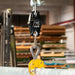 Digital hanging scale with a hook in a warehouse setting