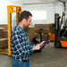 Man operating a forklift with a Particle counter in a warehouse setting
