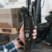 Hand holding a Particle counter in front of a forklift