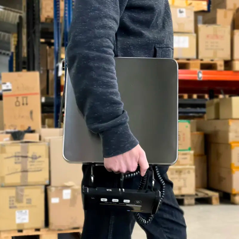 Person holding a scale in a warehouse setting