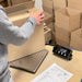 Person preparing a package with a digital scale on a table