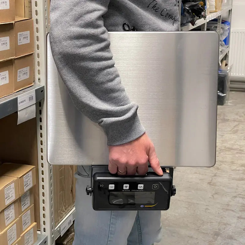 Person holding a scale in a warehouse setting