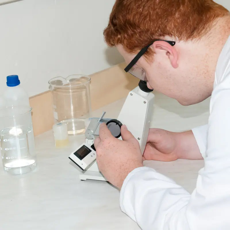 Person using a refractometer in a laboratory setting