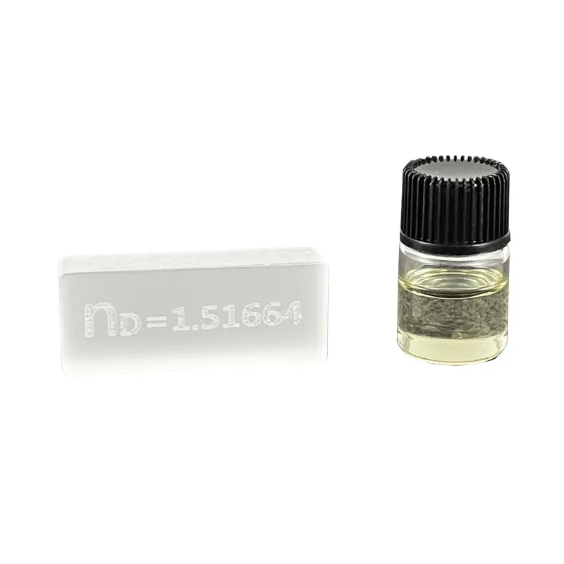 Small glass bottle with a black cap and a white label on a white background