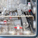 Close-up of a dishwasher with glassware and metal components.