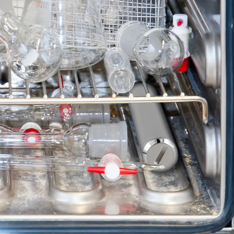 Close-up of a dishwasher with glassware and metal components.