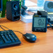 Digital thermometer on a desk with computer equipment