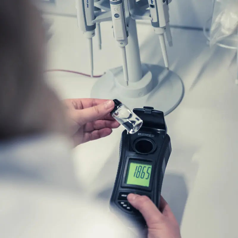 Person using a Turbidity Meter to measure a sample in a laboratory setting