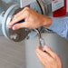 Person adjusting a valve with a tool in a mechanical setting