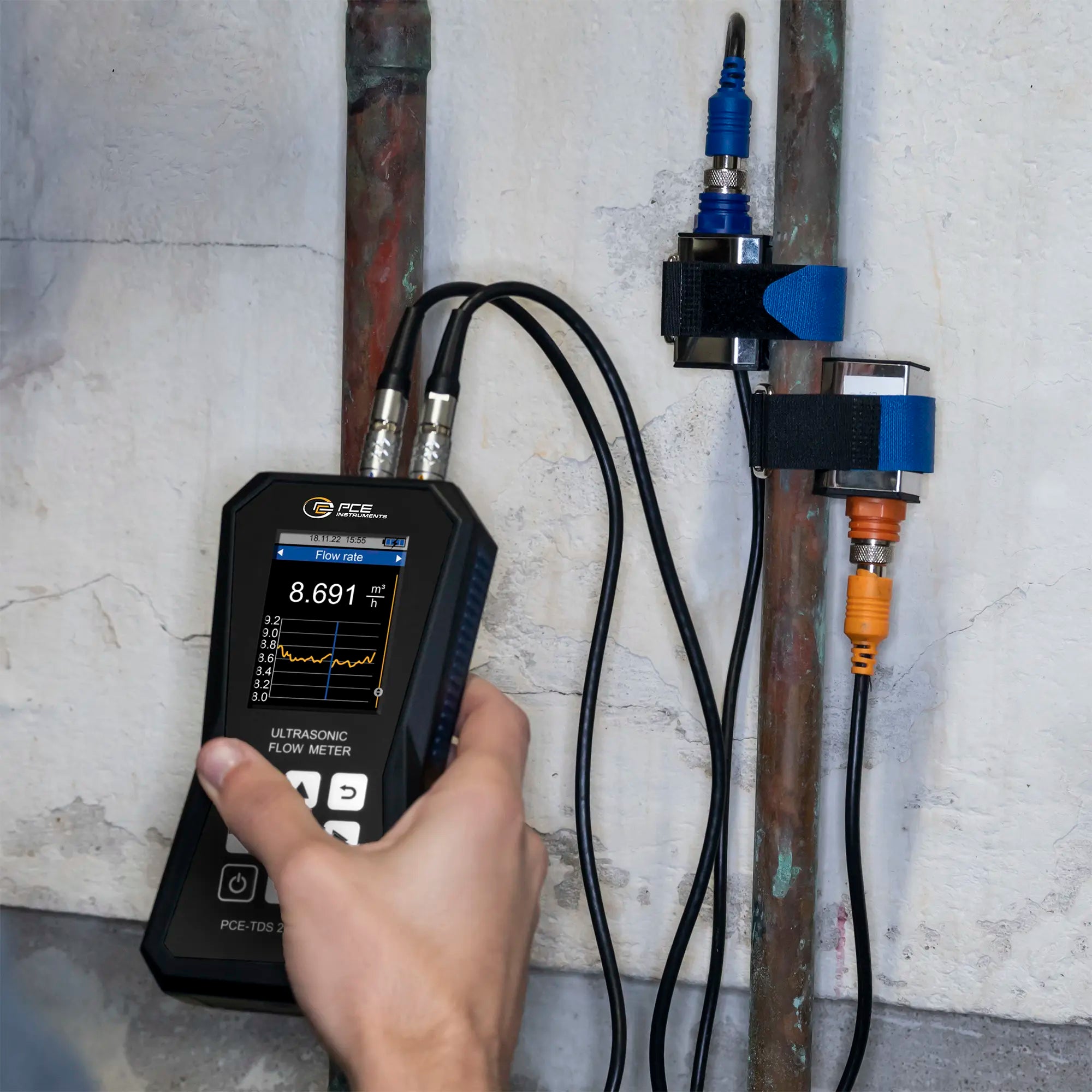 someone using an ultrasonic flow meter with sensors