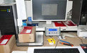 Packaging scale with a computer and office supplies on a desk