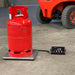 Red propane tank on a scale with a digital display in a warehouse setting